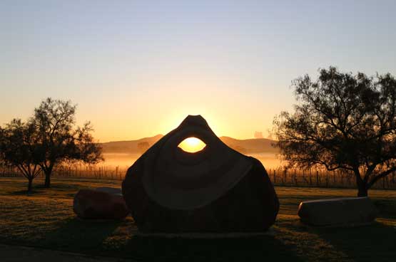 A pierced sandstone sculpture against the sunset