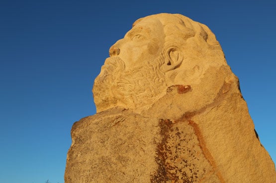A carved sandstone face against a blue sky